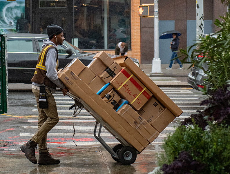 A delivery driver using mobility software for routing, scheduling, and tracking parcels